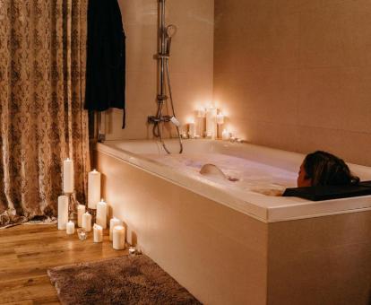 Mujer disfrutando de la bañera de hidromasaje privada de la suite del alojamiento.