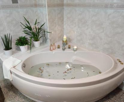 Bañera de hidromasaje privada con romántica decoración de la Suite.