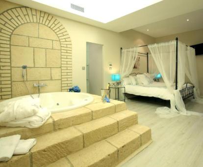 Preciosa Suite con bañera de hidromasaje junto a la cama.