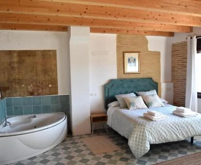 Suite con bañera de hidromasaje cerca de la cama.