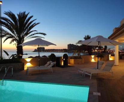 Agradable zona exterior con piscina al aire libre, solariium y vistas al mar de este hotel con encanto.