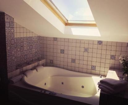 Baño con bañera de hidromasaje de la suite con terraza del hotel.