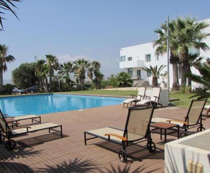 Amplias zonas exteriores de este hotel con encanto con amplia piscina y mobiliario al aire libre.