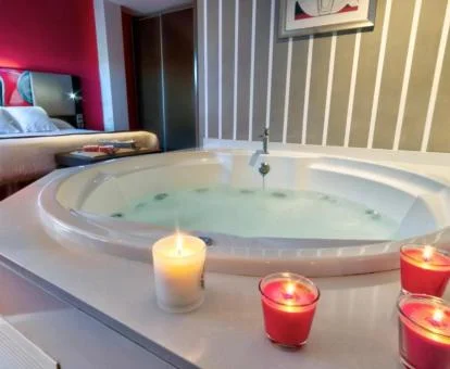Habitación Doble Confort con bañera de hidromasaje privada cerca de la habitación y decorada con velas.