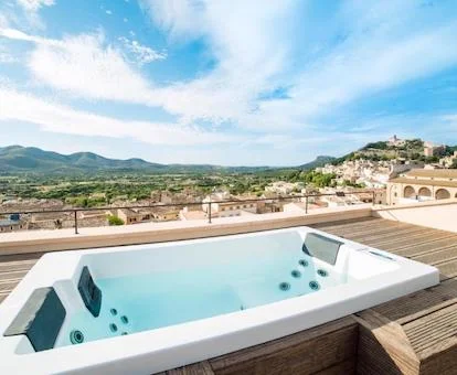 Jacuzzi en la terraza con vistas a la montaña en la terraza de la Suite con Terraza