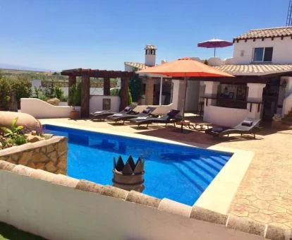 Coqueto edificio de este hotel con encanto con piscina exterior y mobiliario al aire libre.