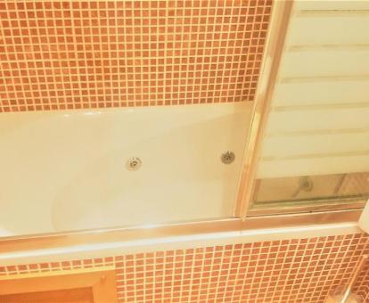 Bañera de hidromasaje privada en el baño de uno de los apartamentos del establecimiento.