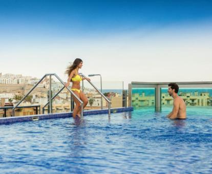 Pareja disfrutando de la piscina con fabulosas vistas de este hotel con encanto.