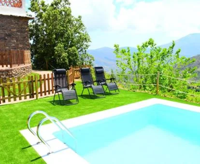 Zona exterior con piscina y solarium de este complejo de apartamentos rodeado de naturaleza.