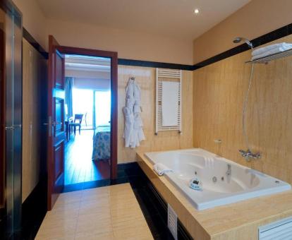 Amplio baño con bañera de hidromasaje privada de la Suite con vistas al mar del hotel.