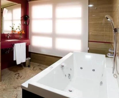 Baño con bañera de hidromasaje privada de la Suite Junior Deluxe.