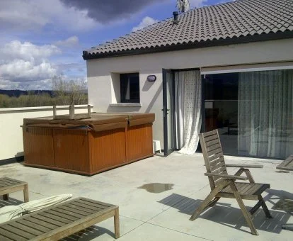 Terraza con un gran jacuzzi exterior de la Suite Junior del hotel.