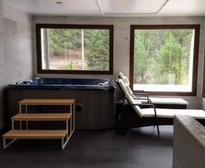 Zona de bienestar con jacuzzi y vistas al exterior de este acogedor hotel.