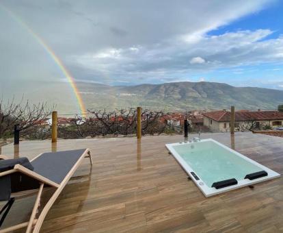 Amplia terraza con vistas a las montañas y jacuzzi privado de la Suite Deluxe del alojamiento.