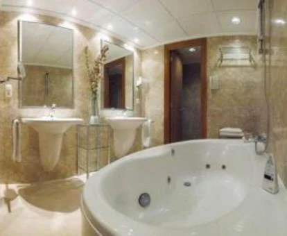 Bañera de hidromasaje privada en el baño de la Suite con balcón y vistas al mar.