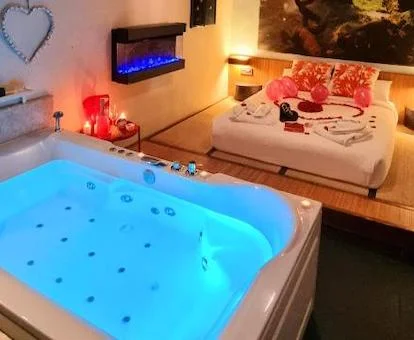 Bañera de hidromasaje privada frente a la cama en uno de los apartamentos del establecimiento.