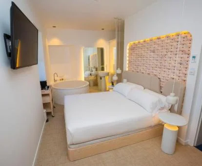 Dormitorio de una de las preciosas habitaciones con bañera junto a la cama.