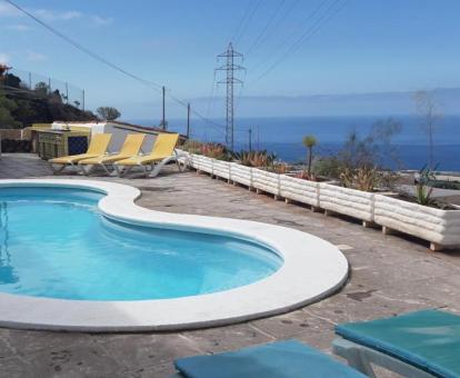 Terraza con mobiliario, piscina al aire libre y vistas al mar de este hotel.