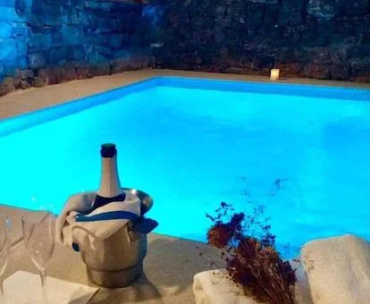 Foto del jacuzzi con iluminación y dos copas con su botella de cava en el exterior de El Forn Freixenet