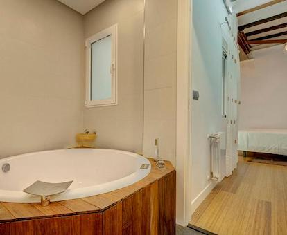 Bañera de hidromasaje circular en el baño y cerca de la cama en el apartamento Friendly Rentals Boyvin de la ciudad de Valencia