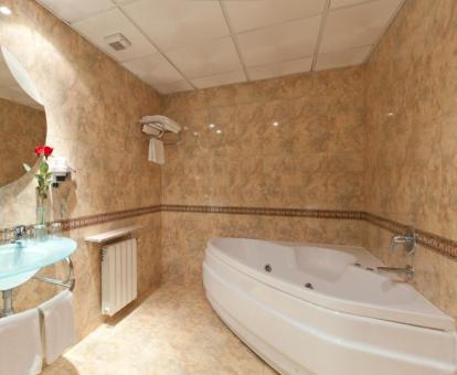 Baño con bañera de hidromasaje privada de la suite superior del hotel.