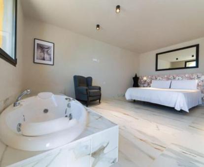 Dormitorio con bañera de hidromasaje privada de una de las habitaciones del hotel.