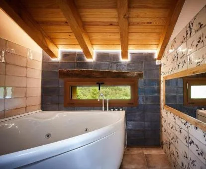 Baño con bañera de hidromasaje privada de uno de los apartamentos con vistas al jardín.