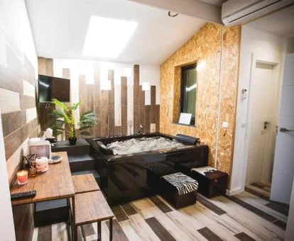 Maravillosa zona de bienestar con un gran jacuzzi para dos personas de la habitación con cama grande del hotel.