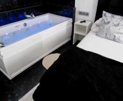 Bañera de hidromasaje junto a la cama de una de las habitaciones del hotel.