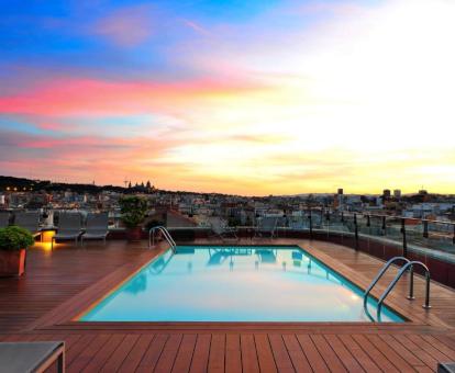 Terraza con piscina exterior y vistas a la ciudad de este hotel con encanto.