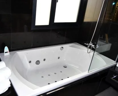 Baño de la Habitación con cama grande y bañera de hidromasaje privada.