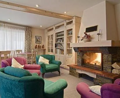 Acogedor salón común con chimenea de este hotel rural.