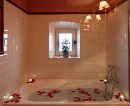 Bañera de hidromasaje decorada con pétalos de rosa de la Habitación Doble Superior con vistas al jardín - Tabaco.