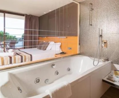 Amplio jacuzzi privado cerca de la cama en la habitación doble superior del hotel.