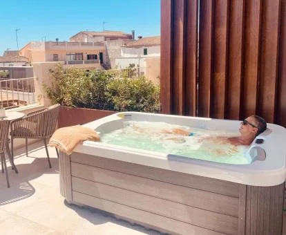 Hombre disfrutando del jacuzzi privado en la terraza de la Habitación Doble Deluxe.