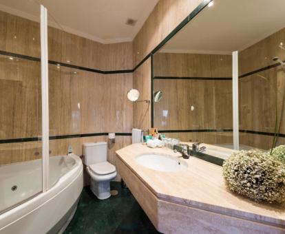 Baño con bañera de hidromasaje privada de la habitación doble Deluxe del hotel.