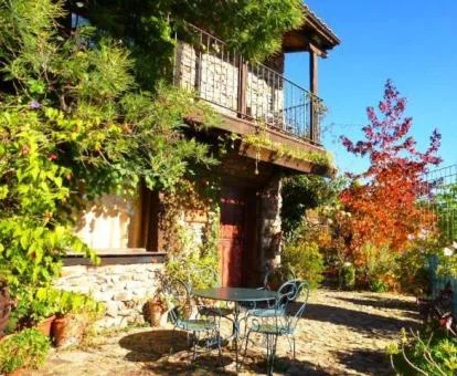 Edificio rodeado de jardines y vegetación de este hotel con encanto con mobiliario al aire libre.