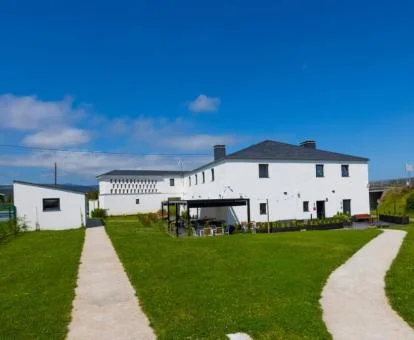 Acogedor hotel con amplias zonas verdes y mobiliario exterior.