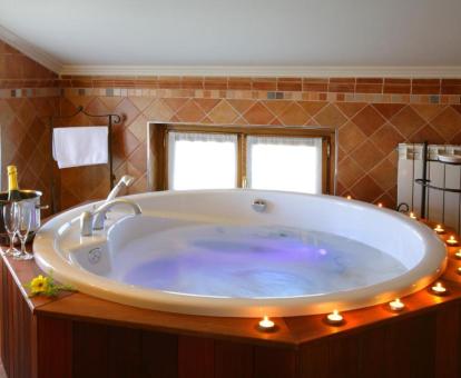 Preciosa bañera de hidromasaje circular con decoración romántica de la suite junior del hotel.
