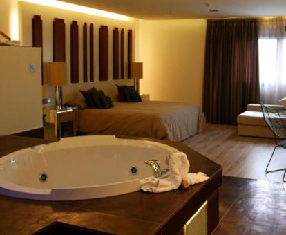 Una de las preciosas habitaciones con bañera de hidromasaje privada junto a la cama del hotel.