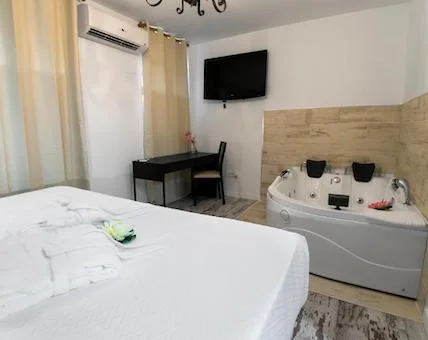 Foto del jacuzzi para dos personas en el fondo de la habitación Deluxe con Jacuzzi grande, y que está junto a la cama
