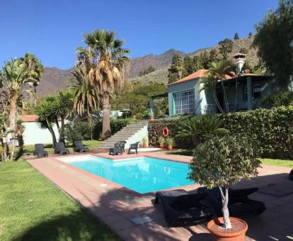 Zona exterior con jardín y piscina de este establecimiento de casas rurales.