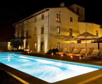 Edificio con una amplia piscina exterior e iluminación nocturna de este hotel con encanto.