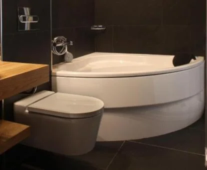 Baño de la suite con bañera de hidromasaje y cama grande.