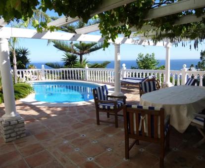 Terraza con mobiliario, piscina y vistas al mar de este acogedor hotel.