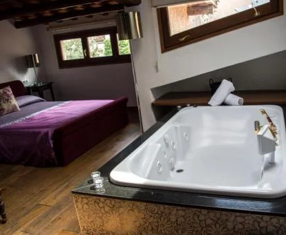 Jacuzzi privado junto a la cama de una de las habitaciones del hotel.