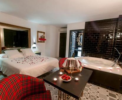 Preciosa suite con decoración romántica y jacuzzi junto a la cama llamada La alcoba de la reina.