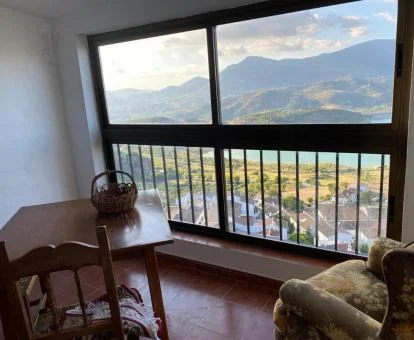 Sala de estar con amplios ventanales con vistas a la naturaleza de esta coqueta casa rural.