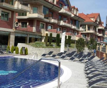 Edificio de este hotel con encanto con piscina exterior rodeada de tumbonas.