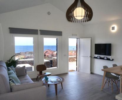 Sala de estar con televisión y vistas al mar de este alojamiento independiente.